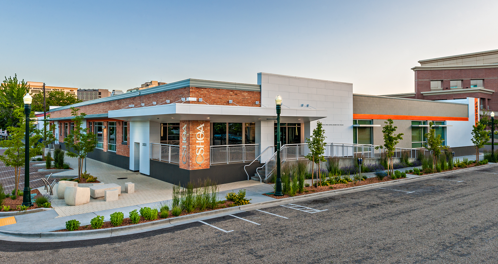 CSHQA’s Boise headquarters at 2nd and Broad, a renovated brick warehouse with a glass-and-steel entry, landscaping, and diagonal parking.