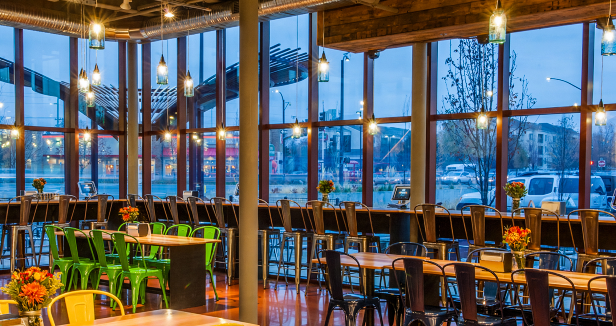 Communal tables and colorful chairs line the floor-to-ceiling windows of the River Room at Boise’s Whole Foods Market.